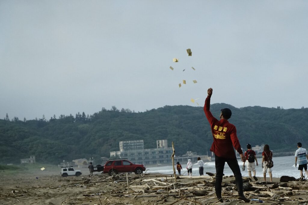 許修逸出海之前撒金紙祈福，祈求海象平順、漁獲滿盈。攝影／黃是瑀